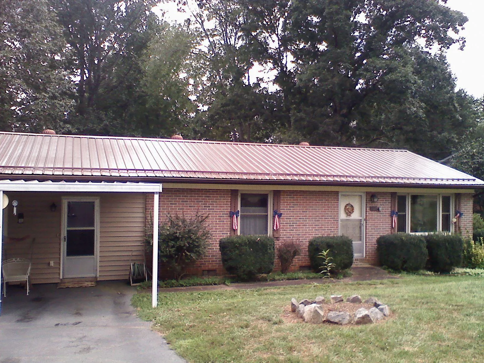 Bronze metal roof and carport on a brick ranch home — Roof Repair work by our crew in Flagler